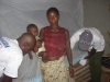 Volunteers assembling the mosquito net at the home of mother and child