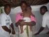 Volunteers assembling the mosquito net at the home of mother and child