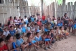 A large group of kids sit with their newly acquired bednets in Belen