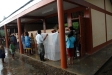 Even inadequate rain shelter does not deter volunteers from demonstrating the proper use of a bednet in Nvo Alegria