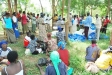 People wait outside the barrier for their turn to receive netting.