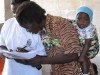 One mother signs for a net which will now protect this toddler who has very low immunity to malaria.