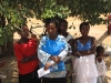 Women enjoy the shade at the mosquito net distribution site.