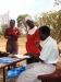 A World Vision team member distributes nets and calls up community members to sign for their new nets.