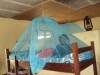 A young girl shows off her new net at Nanguruwe. Most Tanzanians are at risk of malaria. The bednet will lower her risk substantially.