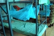 Buigiri School for the Blind: One girl carefully ties a net to her bed.