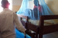Mundemu School: One pupil comfortably sits, reading underneath the cover.