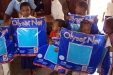 Poloni: These young students hold up their new LLIN (Long Lasting Insecticidal Nets) which will protect their sleeping spaces for 5 years. The insect repellant is safe for small children, but deadly to mosquitos.