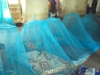 After much effort climbing on ladders and placing hooks into ceilings, many beds are successfully covered by a protective mosquito net.