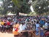 Villagers are given informational handouts.