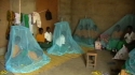 Mnara Sec. School – Students try out their new LLINs over the sleeping spaces they share.