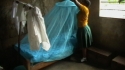 Nyangao Sec - A young girl hangs a new net over her bed.