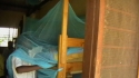 Ruo Sec. School - A student makes sure his net is properly tucked beneath his mattress to ensure full coverage.