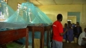 Rondo Seminary - A volunteer makes sure the LLINs in this boys’ room are hung properly to ensure the best possible protection from malaria.