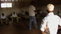 FARM 17 : In one of the dormitories, the young males are instructed on the importance and use of the mosquito nets.
