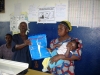 Butaw Clinic - mother with child receiving her net (inside the blue package)