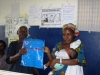 Butaw Clinic - young mother with child receiving her net (inside the blue package)