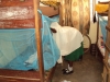 Mnyambe Sec. - A female student makes sure her net is tucked underneath the mattress properly to ensure that it will cover her fully.