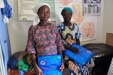 Two proud expectant mothers hold their new AMF long-lasting insecticide treated bed nets.