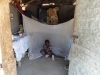A child, Irongu Mariam, sits beside her bed net during a home visit.