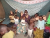 Rosemarie with family and neighbor children rejoice at having a bed net under whihc to sleep. 'Eyalama Noi Noi, AMF!' (Thank you very much AMF!)