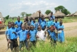 Village children cheer as one of the group holds an information sheet about the distribution.