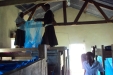Bereko School: Two young girls offer each other support in raising the nets over their beds.