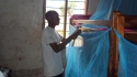 Tumaini: One student uses a hammer and nails to attach a net to his bunk bed.